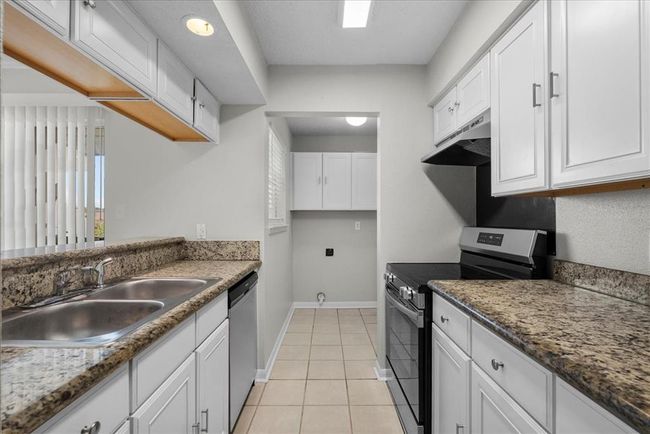 Sleek kitchen with the laundry room tucked perfectly to the side. Function meets fabulous. | Image 11