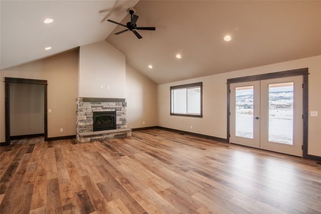 Unfurnished living room with a fireplace, light hardwood / wood-style floors, french doors, and ceiling fan | Image 5