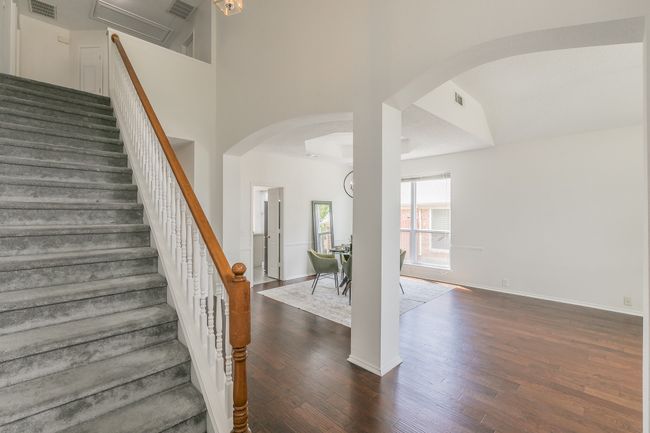 Stairs featuring arched walkways, wood finished floors, visible vents, and baseboards | Image 6