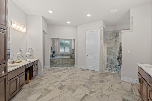 Bathroom with two vanities, a garden tub, baseboards, and tiled shower | Image 17