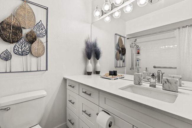 Bathroom featuring curtained shower, toilet, and vanity | Image 14