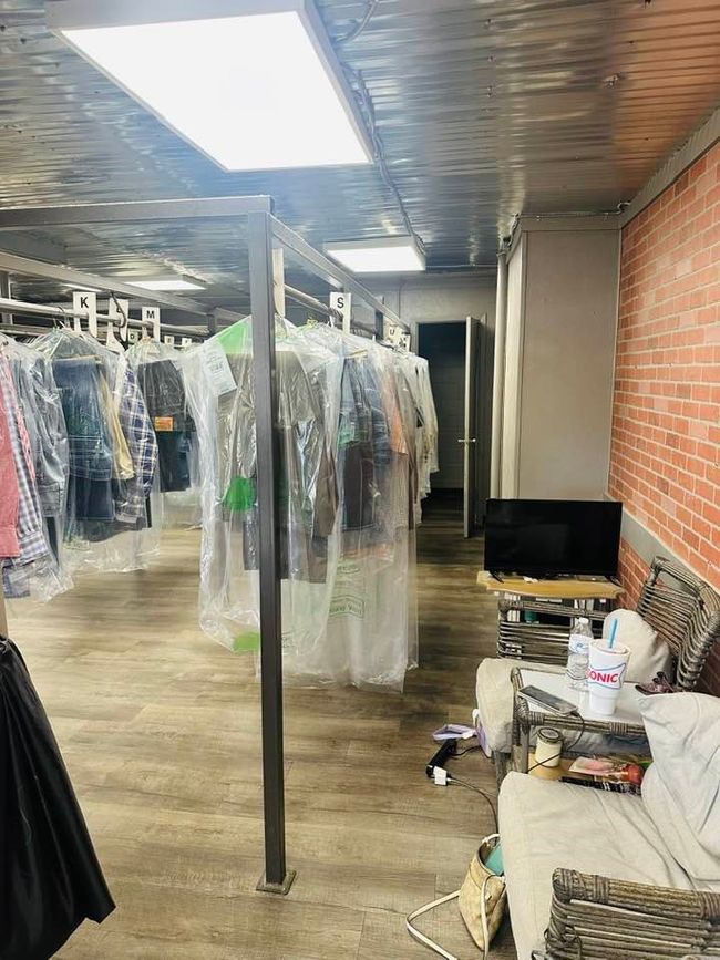 Interior of cleaners featuring brick wall and wood finished floors. | Image 4