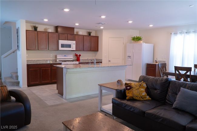 Kitchen with visible vents, light carpet, a sink, white appliances, and open floor plan | Image 35