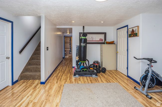Workout area with baseboards, wood finished floors, and a textured ceiling | Image 17