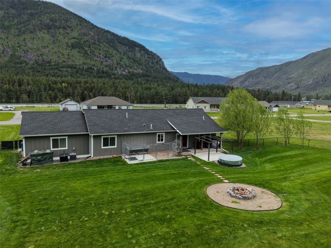 Rear view of property with an outdoor fire pit, a mountain view, a patio area, and a shingled roof | Image 39