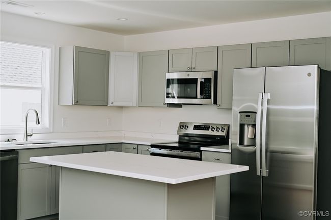 Kitchen with appliances with stainless steel finishes, sink, gray cabinets, and a kitchen​​‌​​​​‌​​‌‌​‌‌​​​‌‌​​‌‌​‌​​​​​‌ island | Image 4