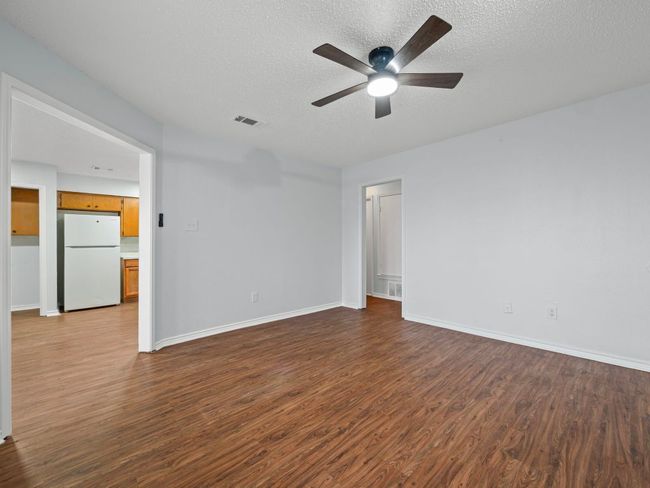 Spare room with dark wood finished floors, ceiling fan, and a textured ceiling | Image 8