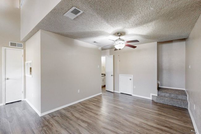 Empty room featuring a ceiling fan, wood finished floors, visible vents, and baseboards | Image 14