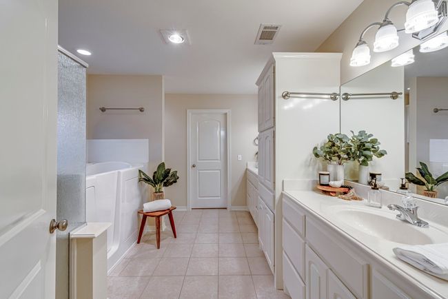 Bathroom with tile patterned floors, vanity, and a washtub | Image 4
