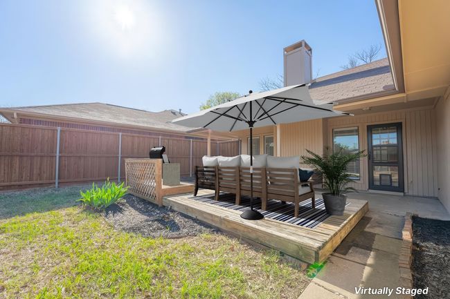 View of yard featuring a decked patio, covered patio and virtually staged furniture and accessories | Image 22