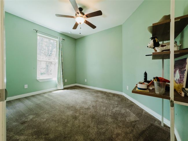 Carpeted spare room featuring a ceiling fan and baseboards | Image 27
