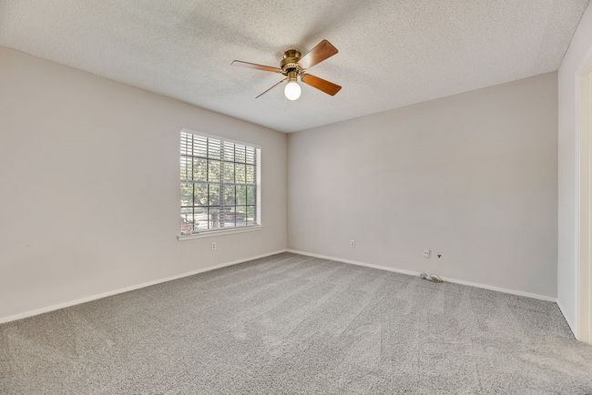 Carpeted spare room with a ceiling fan and a textured ceiling | Image 11