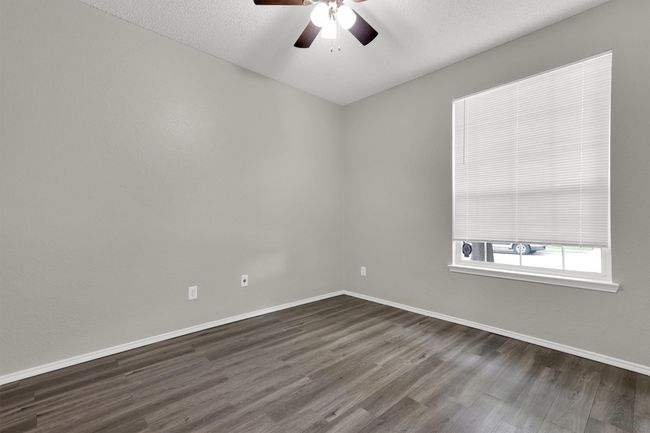 Spare room featuring dark wood-style flooring, baseboards, a ceiling fan, and a textured ceiling | Image 14