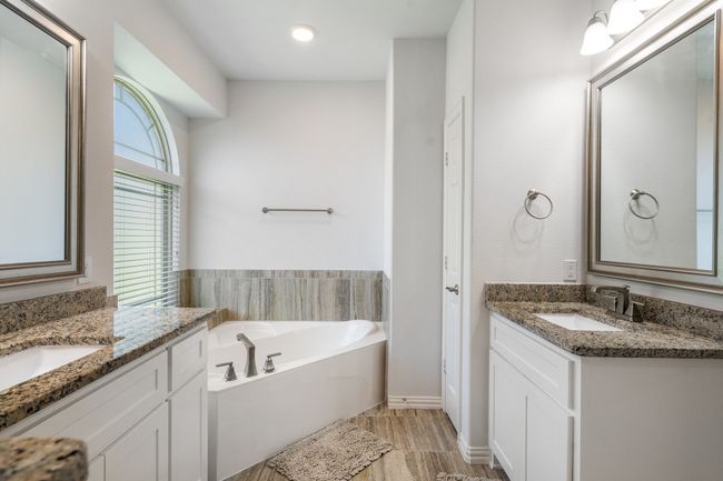 Full bathroom featuring two vanities and a bath | Image 23