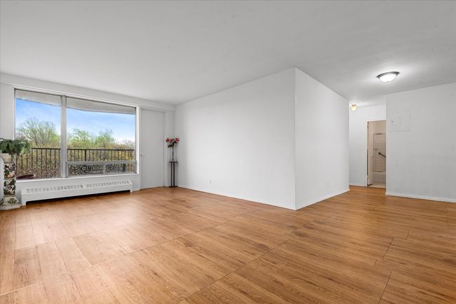 Spare room featuring light wood-style flooring, baseboards, a baseboard radiator, and radiator | Image 4