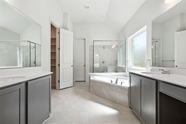 Full bath with two vanities, lofted ceiling, a shower stall, a garden tub, and a walk in closet | Image 21
