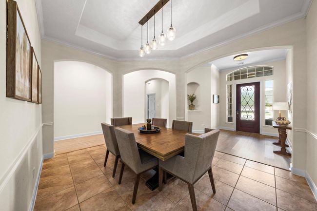 The formal dining room exudes sophistication with ample natural light highlighting the tile flooring and open layout. Ideal for entertaining, this elegant space harmonizes functionality and style, setting a graceful tone for memorable gatherings. | Image 20