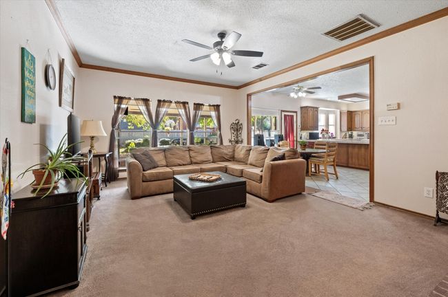 Warm and inviting family room with tons of space to enjoy catching up with friends and family. This space looks out to the huge covered patio and lush backyard retreat. | Image 23