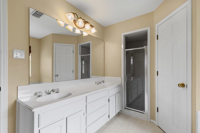 Bathroom featuring double vanity, a shower stall, and tile patterned floors | Image 16