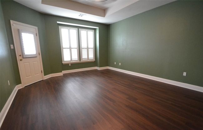 Spare room with plenty of natural light, dark wood finished floors, and a tray ceiling | Image 12