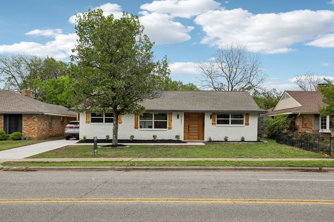 Ranch-style home with brick siding, fence, concrete driveway, and a front yard | Image 26