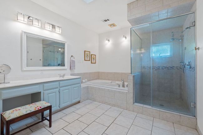 Bathroom featuring vanity, a bath, a shower stall, and tile patterned flooring | Image 22