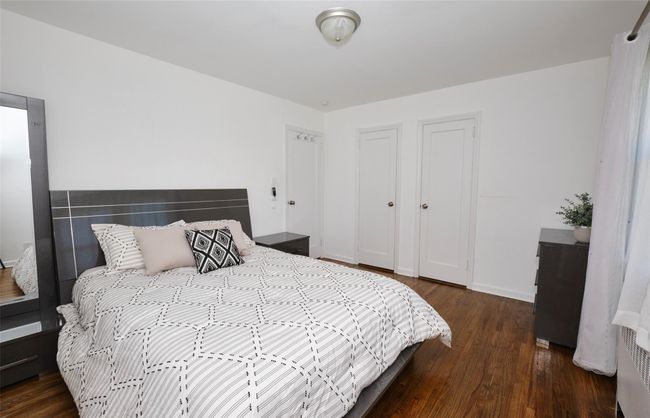 Bedroom featuring wood finished floors and baseboards | Image 16