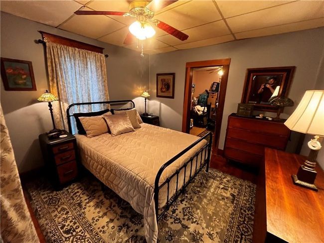 Bedroom featuring wood finished floors, a drop ceiling, and a ceiling fan | Image 15