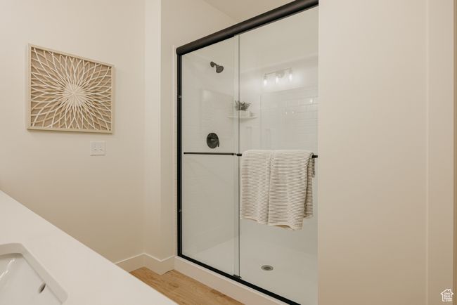 Bathroom featuring a sink, baseboards, a stall shower, and wood finished floors | Image 19