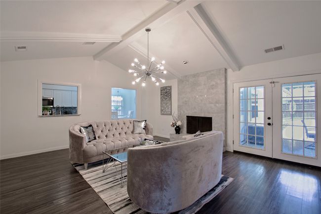 Living area with dark wood finished floors, healthy amount of natural light, and a chandelier | Image 8