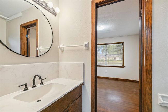 1/2 bath (jack and jill) shared with bedroom #1 and Bedroom #2. Updated faucet and counter top. New mirror and light fixture | Image 21