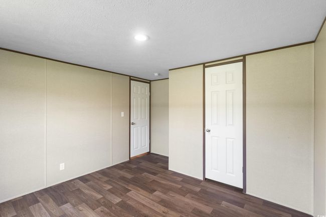 Unfurnished bedroom featuring dark wood-style flooring, a textured ceiling, a closet, and recessed lighting | Image 29