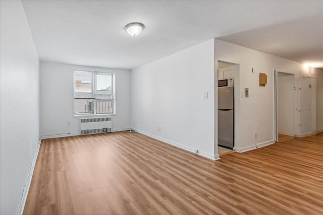Spare room featuring radiator and light wood-style floors | Image 8