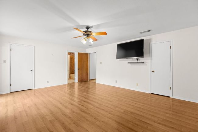 Unfurnished living room with a ceiling fan and light wood-style floors | Image 17