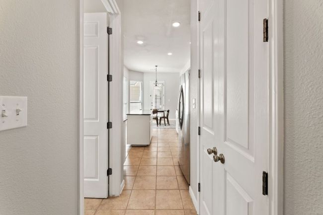 Hallway featuring light tile patterned flooring, recessed lighting, and a textured wall | Image 10