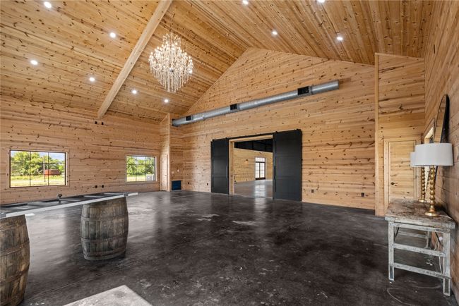 Front foyer with high vaulted ceiling, wooden ceiling, wood walls, and a chandelier | Image 9