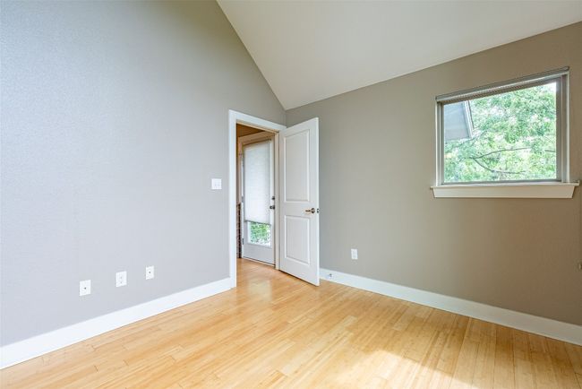 Unfurnished room with healthy amount of natural light, wood finished floors, and lofted ceiling | Image 12