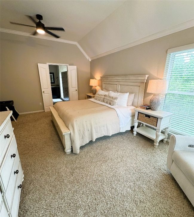 Primary Bedroom with ornamental molding, vaulted ceiling, light colored carpet, and a ceiling fan. | Image 32