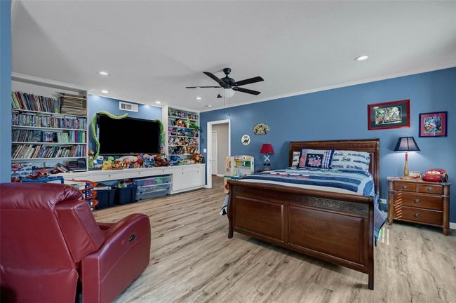 Bedroom featuring wood finished floors, ornamental molding, ceiling fan, and recessed lighting | Image 29
