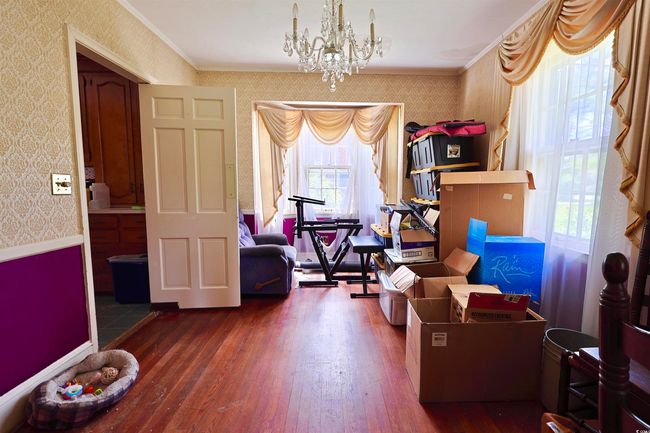 Sitting room featuring wallpapered walls, a chandelier, hardwood / wood-style floors, and crown molding | Image 19