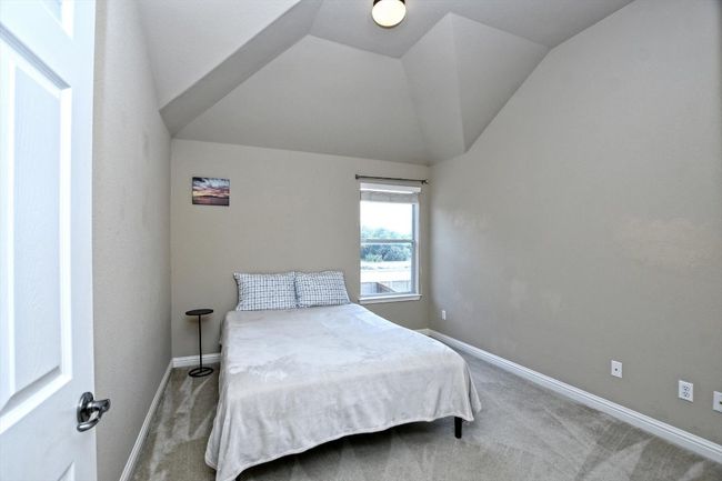Carpeted bedroom with vaulted ceiling and baseboards | Image 23