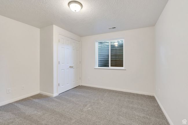Unfurnished bedroom featuring a textured ceiling, carpet flooring, and baseboards | Image 22