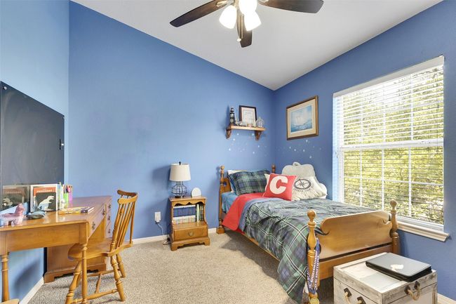 Bedroom featuring multiple windows, lofted ceiling, a desk, baseboards, and carpet floors | Image 27