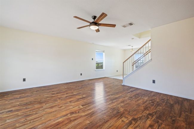 Spare room featuring hardwood / wood-style flooring, stairway, a ceiling fan, and baseboards | Image 13