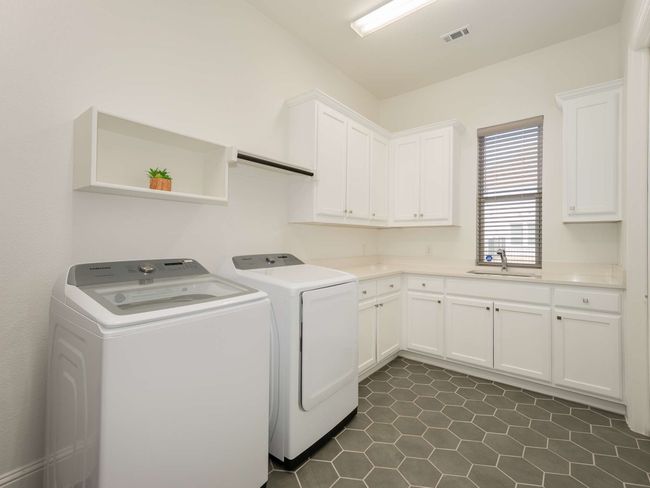 Utility room which includes a sink, additional cabinetry, and plumbing for a refrigerator | Image 26