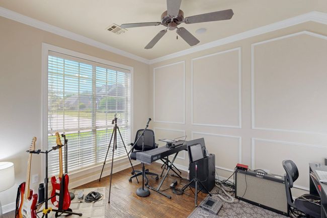 Office space featuring a decorative wall, visible vents, a ceiling fan, and ornamental molding | Image 16