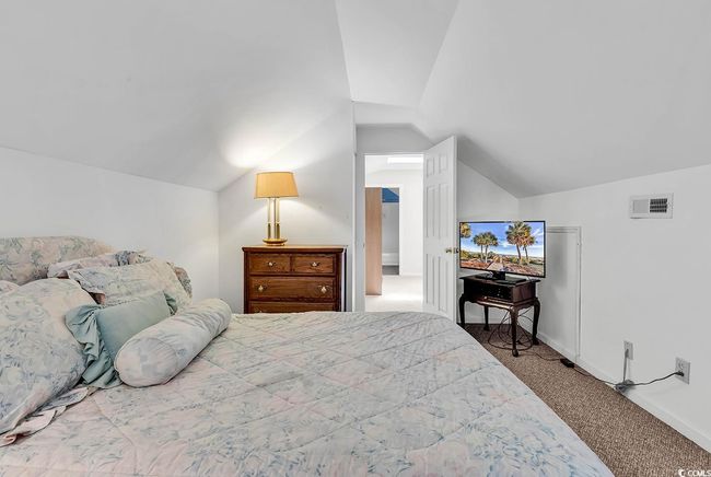 Carpeted bedroom with lofted ceiling and baseboards | Image 30