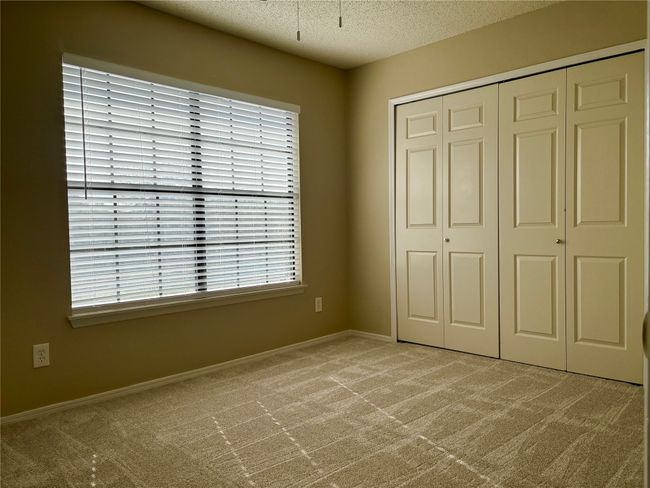 Unfurnished bedroom featuring carpet flooring, baseboards, a closet, and a textured ceiling | Image 16