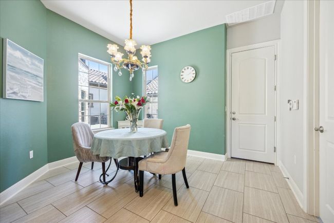 Dining space with baseboards, visible vents, an inviting chandelier, and wood finish floors | Image 12