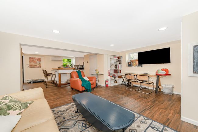 Living area featuring wood finished floors, recessed lighting, baseboards, and a wall unit AC | Image 13